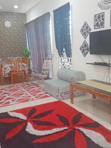 a living room with a couch and a tv at Alif Homestay Changlun in Changlun