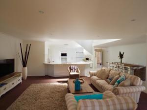 sala de estar con 2 sofás y cocina en Beachfront Retreat - Ducted Air - Free Wifi, en Coffs Harbour