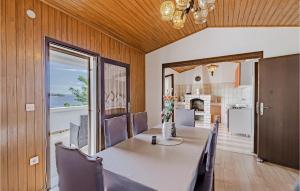 ein Esszimmer mit einem Tisch und Stühlen sowie eine Küche in der Unterkunft Beautiful Home In Prizba With Kitchen in Prizba