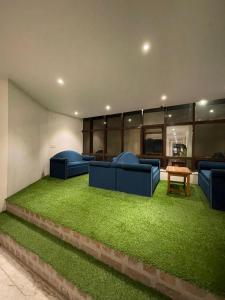 una sala de estar con sofás azules y césped verde en Hotel Sudarshan Palace, en Lātūr