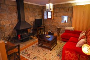 uma sala de estar com um sofá vermelho e uma lareira em Casa da Eira em Baião