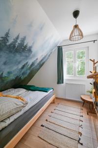 um quarto com uma cama com uma grande pintura na parede em Kotula em AdamÃ³w