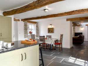 a kitchen and dining room with a table and chairs at Swingletree Cottage in High Nibthwaite