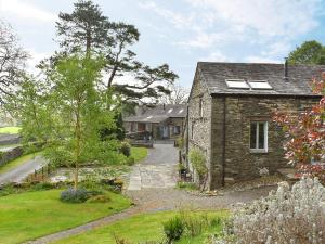 an external view of a stone house with a garden at Swingletree Cottage in High Nibthwaite