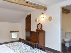 a bedroom with a bed and a sink and a toilet at Swingletree Cottage in High Nibthwaite