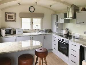 a kitchen with a counter and a clock on the wall at Sage - UK36937 in Lamerton
