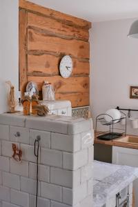 uma cozinha com uma parede de tijolos com um relógio em Kotula em AdamÃ³w