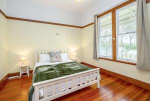 a bedroom with a white bed and a window at Villa Florence in Martinborough