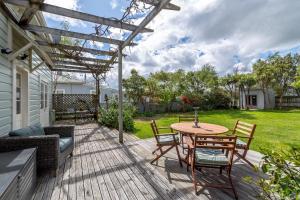 a patio with a table and chairs on a deck at Villa Florence in Martinborough