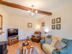 a living room with a couch and a tv at Barbers Bolthole in Masham