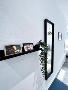 ein Spiegel an einer weißen Wand mit Bildern darauf in der Unterkunft LE PARADIS FISCAL, 5min Bâle, parking privé in Saint-Louis