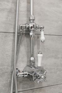 a metal shower fixture with a hose and a shower head at 4 Canon Lane in Chichester