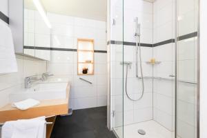 uma casa de banho com um lavatório e um chuveiro em Park-Hotel am Rhein - Gesundheitshotel und Residenzen em Rheinfelden