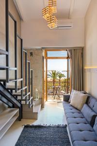 a living room with a blue couch and a staircase at Mitos-Suites in Rethymno Town