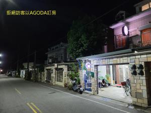 una calle de la ciudad por la noche con una motocicleta estacionada en un garaje en Fire B&B, en Chishang