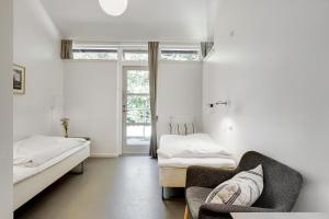 ヒレレズにあるDanhostel Hillerødのベッド2台、ソファ、窓が備わる客室です。