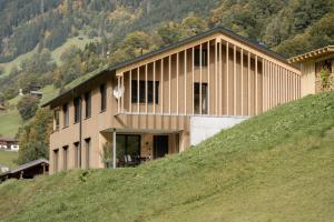 a building on top of a hill with a grassy slope at Apartment Fitsch in Silbertal
