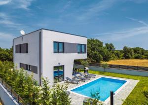 uma casa branca com uma piscina em frente em Villa Tika em Jadreški