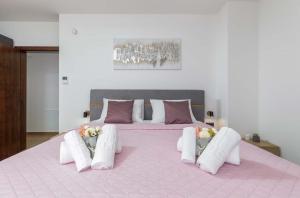 uma grande cama rosa com almofadas brancas em Villa Ana Skicini em Juršići