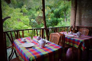 a table with a colorful table cloth on a porch at Ella Green Cottages in Ella +97 photos