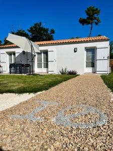 ein Haus mit Kieseinfahrt davor in der Unterkunft Maison neuve au calme idéale pour 4 voyageurs in Les Sables Vignier