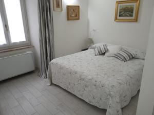 a white bedroom with a bed and a window at Il CORTILETTO Casa Vacanza Trevi in Trevi