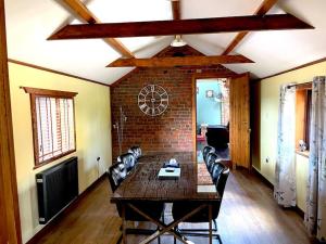 a living room with a table and chairs and a brick wall at 18th century 3 bed Barn- Beautifully converted in Lincolnshire