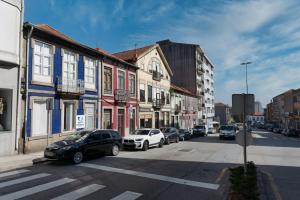una calle de la ciudad con coches aparcados en la calle en Ndussole Guest House, en Oporto
