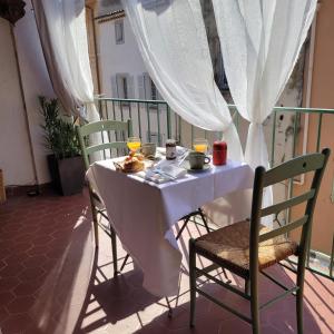 uma mesa branca com 2 cadeiras e bebidas numa varanda em île en Provence em Martigues