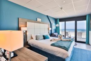 a bedroom with a bed with a teddy bear on it at The Originals Boutique, Hôtel Neptune, Berck-sur-Mer in Berck-sur-Mer