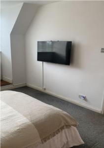 ロンドンにあるWandsworth, South London Deluxe King Room 4の壁に薄型テレビが取り付けられた寝室