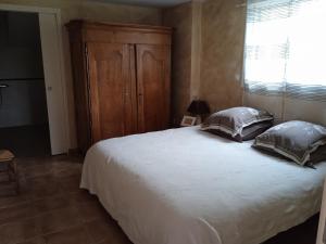 - une chambre avec un grand lit et une armoire en bois dans l'établissement La Closerie de la Hérissière, à La Jaille-Yvon