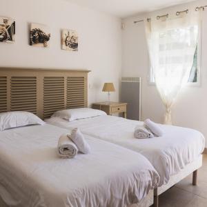 two beds in a bedroom with towels on them at Hotel et Studios Le Marina Baie de La Baule in Pornichet