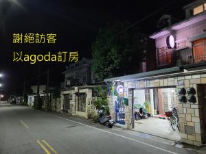 una calle de la ciudad por la noche con una motocicleta estacionada en un garaje en Fire B&B, en Chishang