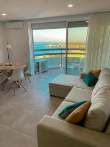 - un salon avec un canapé et une vue sur l'océan dans l'établissement Sunset SeaView Apartment 18 - Torre Verde, à Portimão
