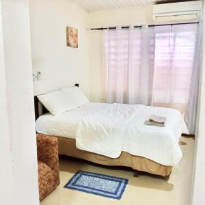 ein Schlafzimmer mit einem weißen Bett und einem Fenster in der Unterkunft Marrets International Hotel - "Express" in Cape Coast