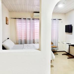 ein weißes Zimmer mit einem Bett und einem Fenster in der Unterkunft Marrets International Hotel - "Express" in Cape Coast