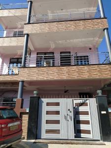 a house with white doors and a balcony at Swapnil Homestay in Varanasi