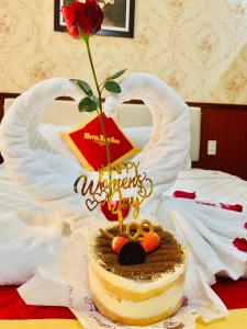 a birthday cake with a rose on top of a bed at Khách Sạn Nam Sơn in Ðông Khê