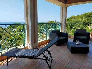patio ze stołem i krzesłami oraz balkonem w obiekcie Appartamento vista mare Corbara, Corsica w mieście Corbara