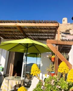 um guarda-chuva verde num pátio com uma mesa em La Casilla del San Antón em Níjar