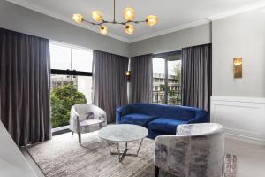 a living room with a blue couch and chairs at Stonehill Suites in Bacolod