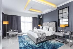 een slaapkamer met een groot bed en een bureau bij Stonehill Suites in Bacolod