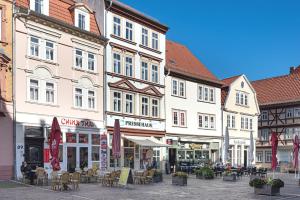 un groupe de bâtiments avec des tables et des chaises dans une rue dans l'établissement Pressehaus Apartment Steinweg, à Mühlhausen