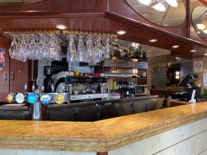 a bar with glasses hanging above a counter at Aero Hotel in Issy-les-Moulineaux