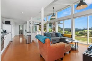 ein Wohnzimmer mit einem Sofa und einem Tisch in der Unterkunft Paroa Bay Chalets - Te Whare Kereru in Russell