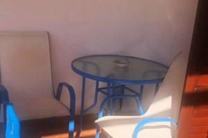 einen blauen Tisch und einen Stuhl in einem Zimmer in der Unterkunft Casa Emma in Favignana