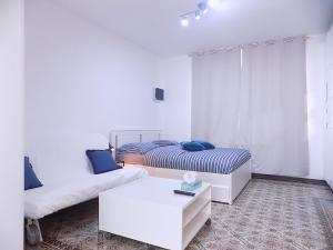 um quarto branco com duas camas e uma mesa em Maison LYDIE - Meublé de vacances 3 étoiles em Charleroi