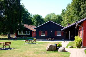 una casa negra y roja con bancos en un patio en Danhostel Hillerød en Hillerød