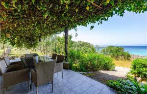 un patio con tavolo, sedie e vista sull'oceano di Awesome Home In Smokvica With Wifi a Smokvica
